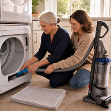 The flat hose attached to a vacuum, reaching into the lint trap slot below the screen